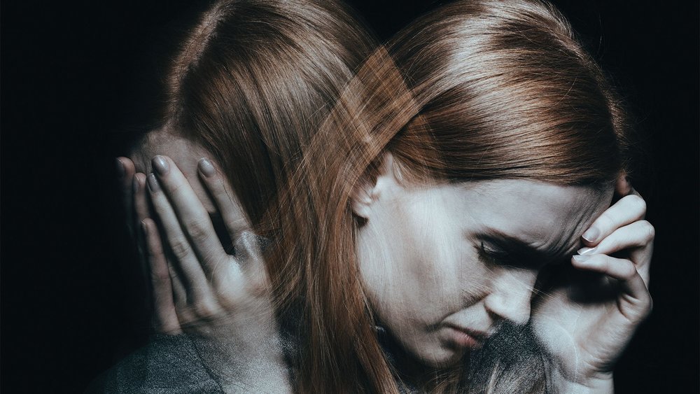 A double exposure portrait shows a distressed woman holding her head with both hands.