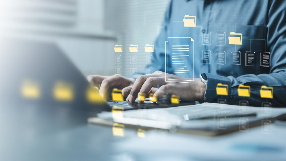 Hands typing on a laptop, overlaid with glowing document icons.