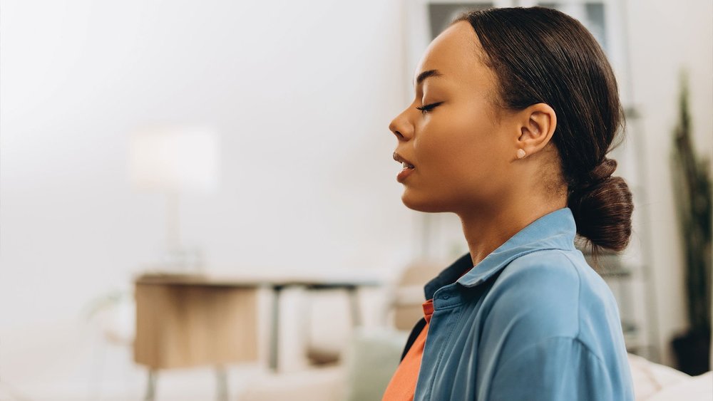 A woman with her eyes closed, breathing slowly.